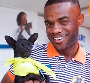 Man holding a small black dog