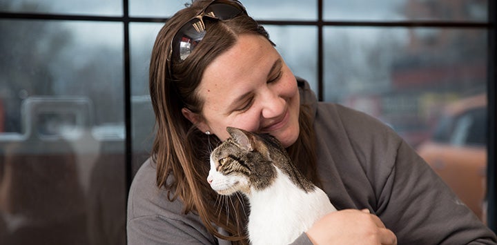 Woman cradling cat she's being reunited with
