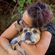 Woman hugging tan dog
