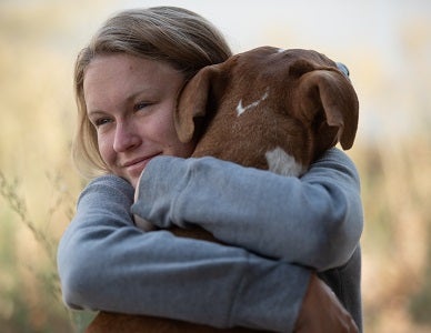 Person hugging dog