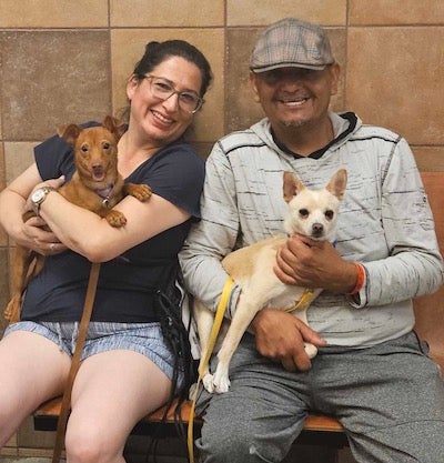 A couple poses for the camera with their newly adopted dog