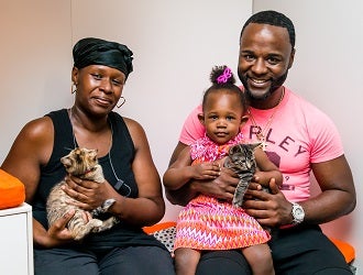 Couple with young daughter holding two kittens