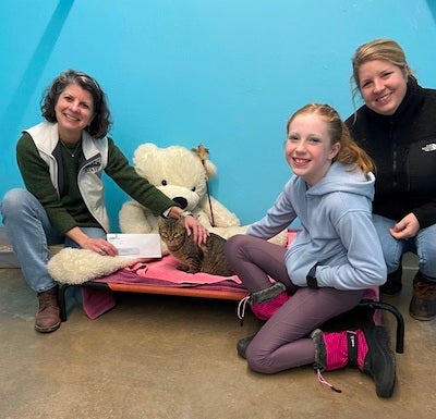A group of people posing with a cat at the Rutland County Humane Society