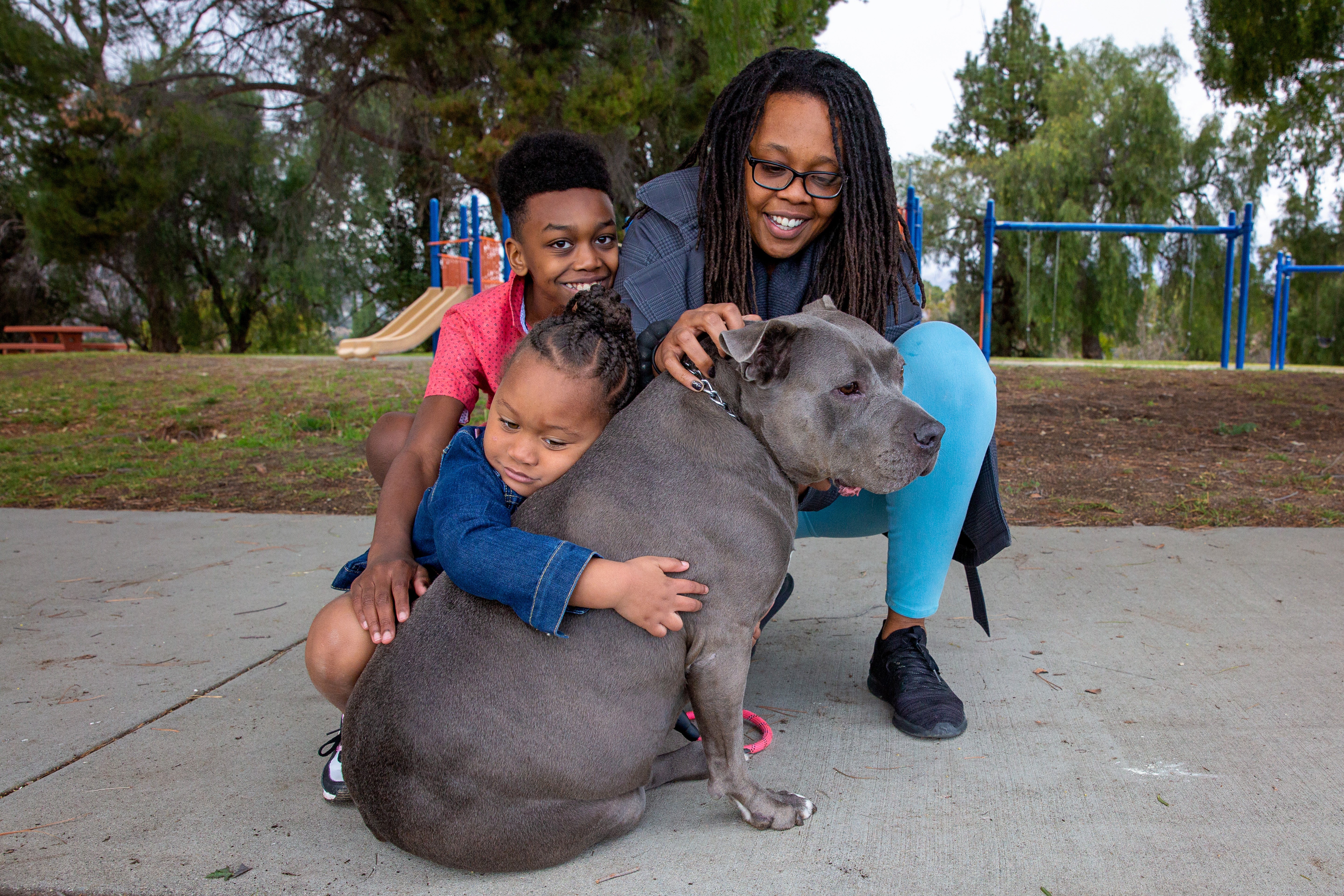 family hugging their dog