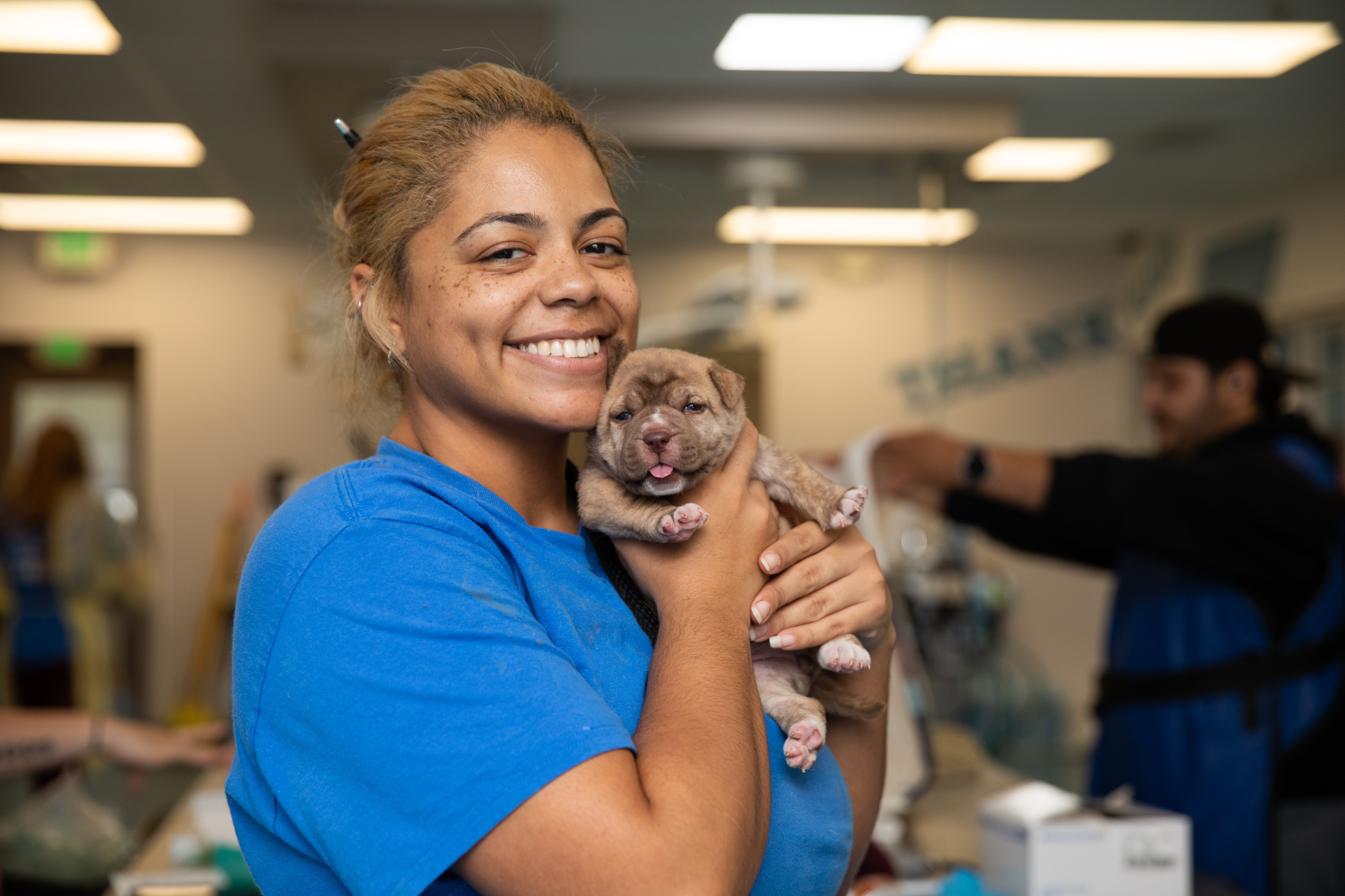 smiling woman holding puppy