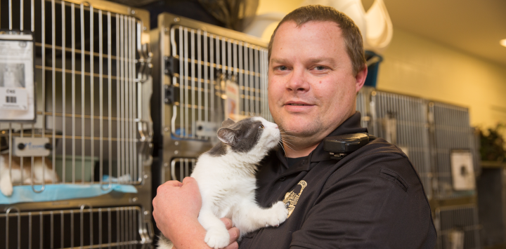animal control officer holding a cat
